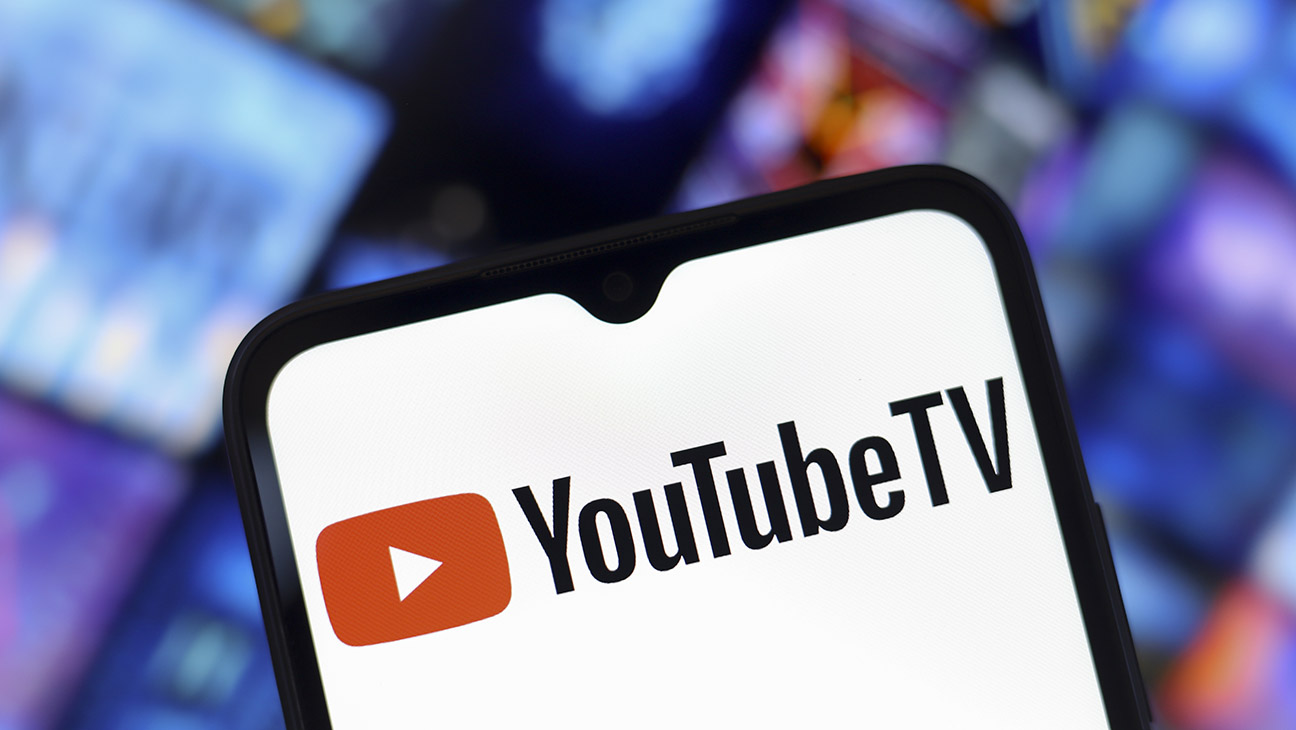 The YouTube TV logo appears on the screen of a smartphone and in the background on the computer screen in Reno, United States, on December 15, 2024.