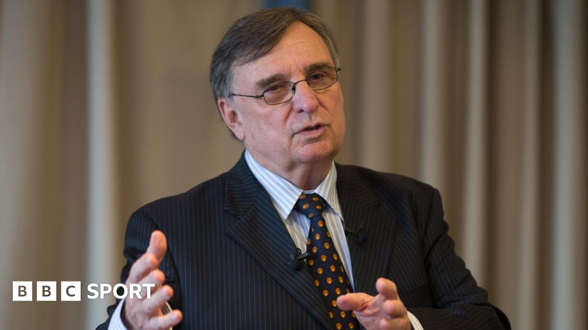 David Moffett wears a dark suit with blue and red tie