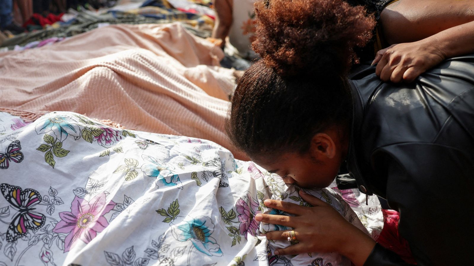 A woman mourns next to the body of a man killed during a police raid in Rio. Pic: AP