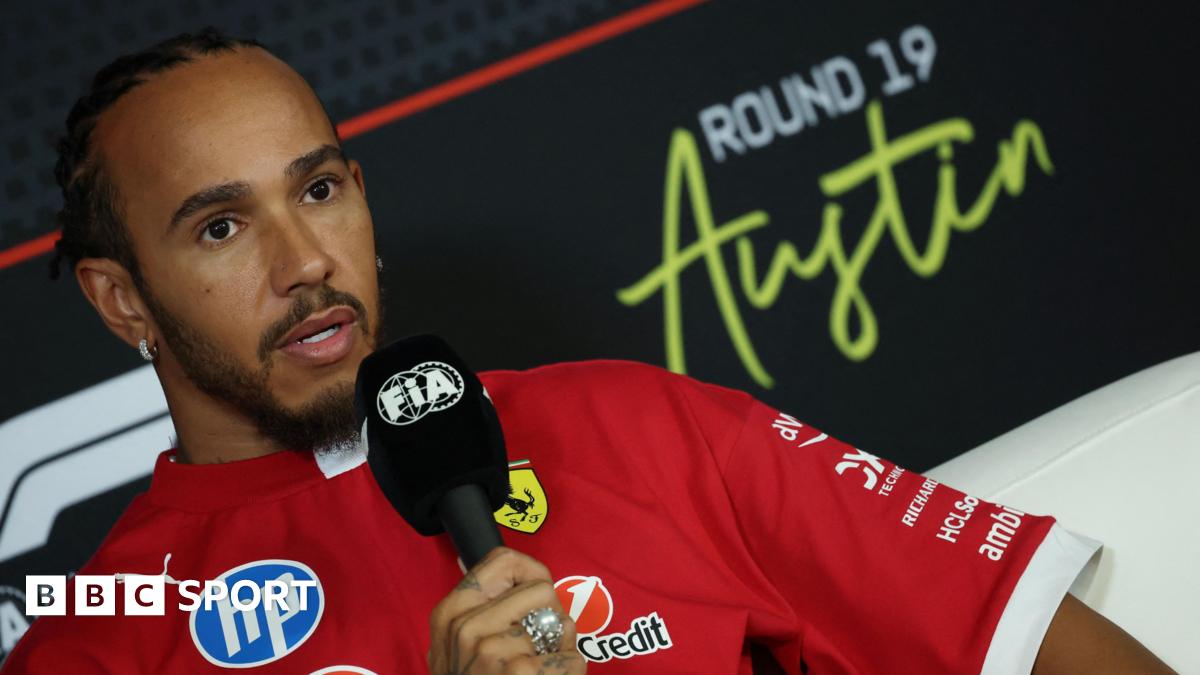 Lewis Hamilton holds an FIA-branded microphone in the United States Grand Prix news conference on Thursday