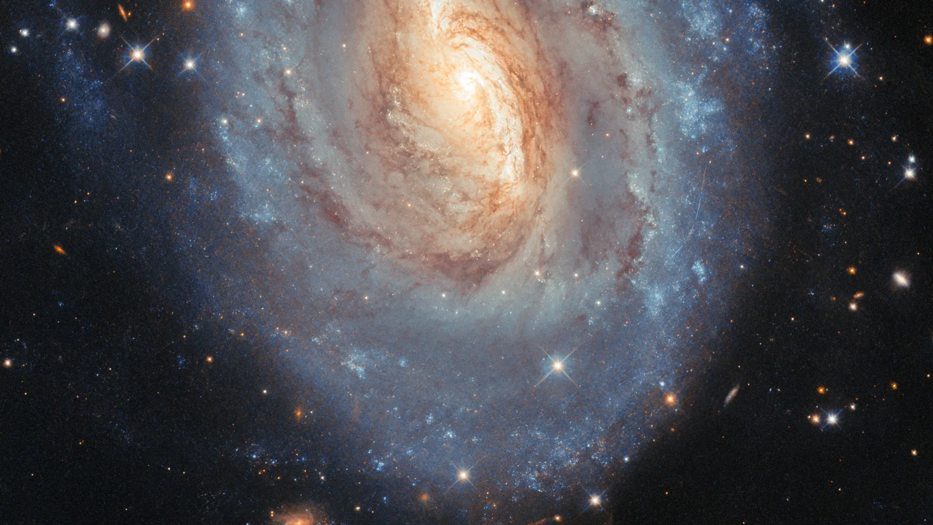 Hubble captura uma galáxia que brilha em azul e ouro