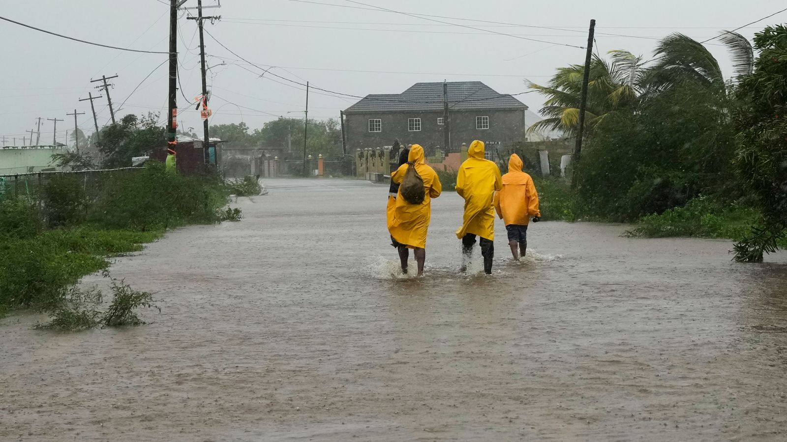 People walk along a road during the passing of Hurricane Melissa in Rocky Point, Jamaica, on Tuesday. Pic: AP