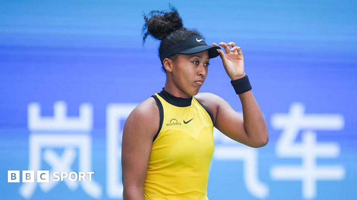 Naomi Osaka looking glum with her hand on her hat