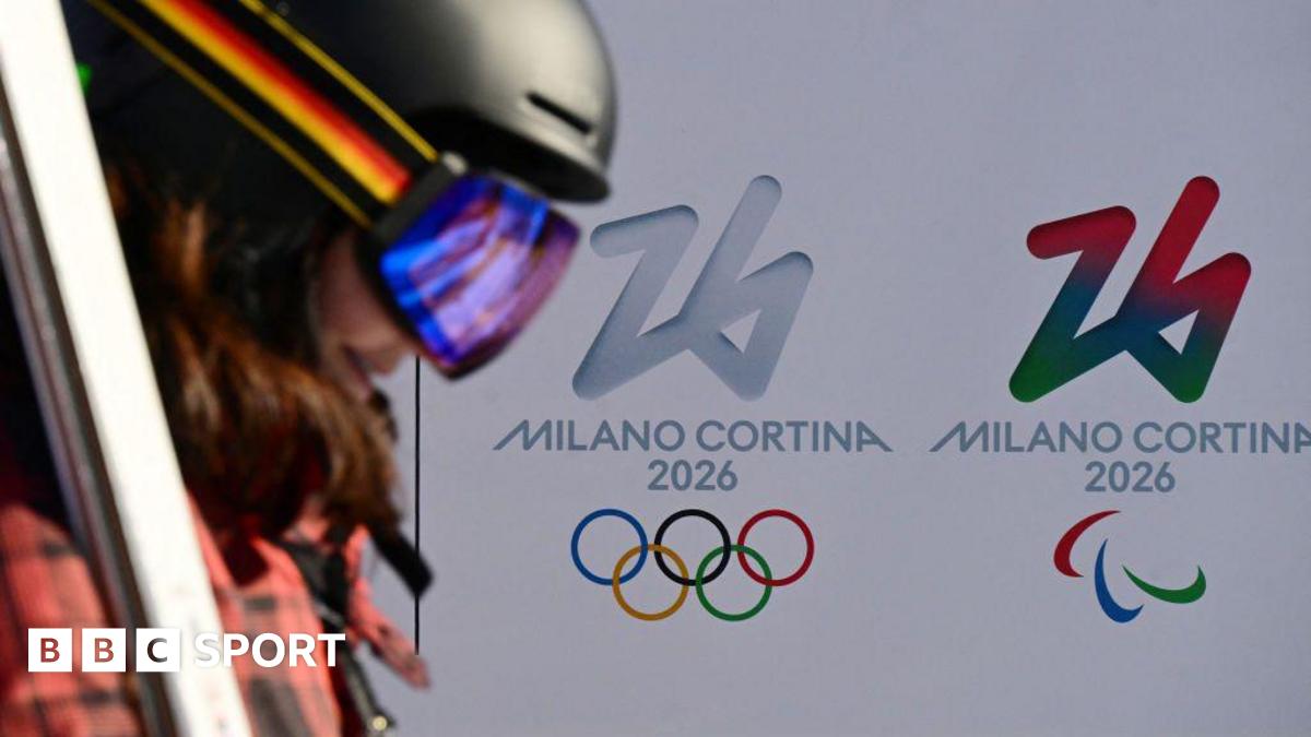 A skier in front of the Olympic and Paralympic logos for the Milano Cortina Winter games