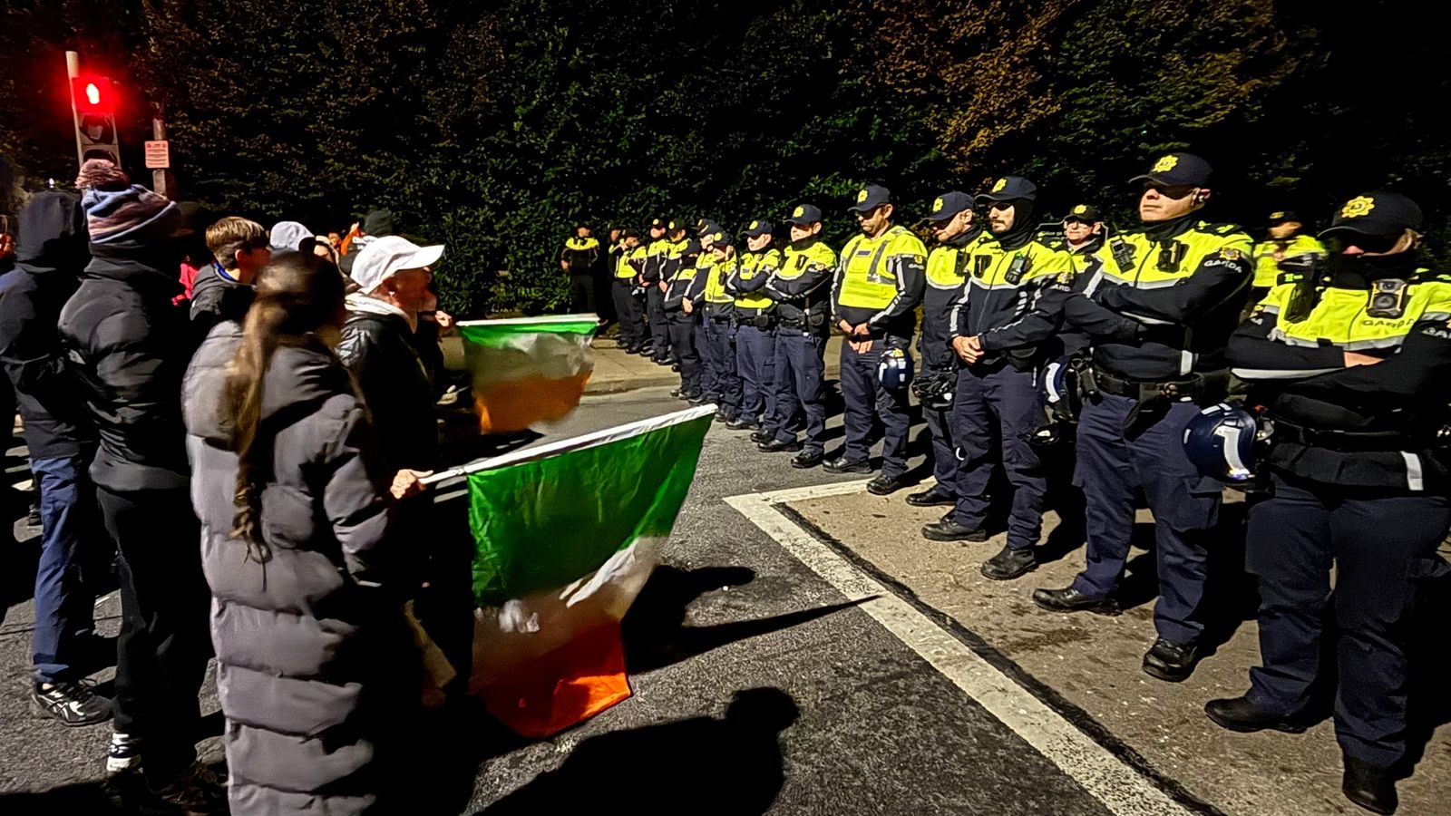 Gardai officers block protesters near the Citywest Hotel in Dublin.  Pic: PA