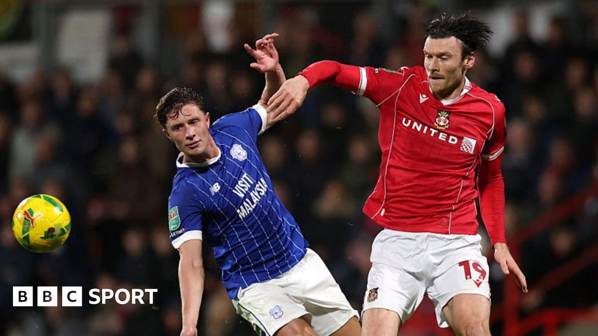 Cardiff City defender Will Fish (L) battles with Wrexham striker Kieffer Moore (R)