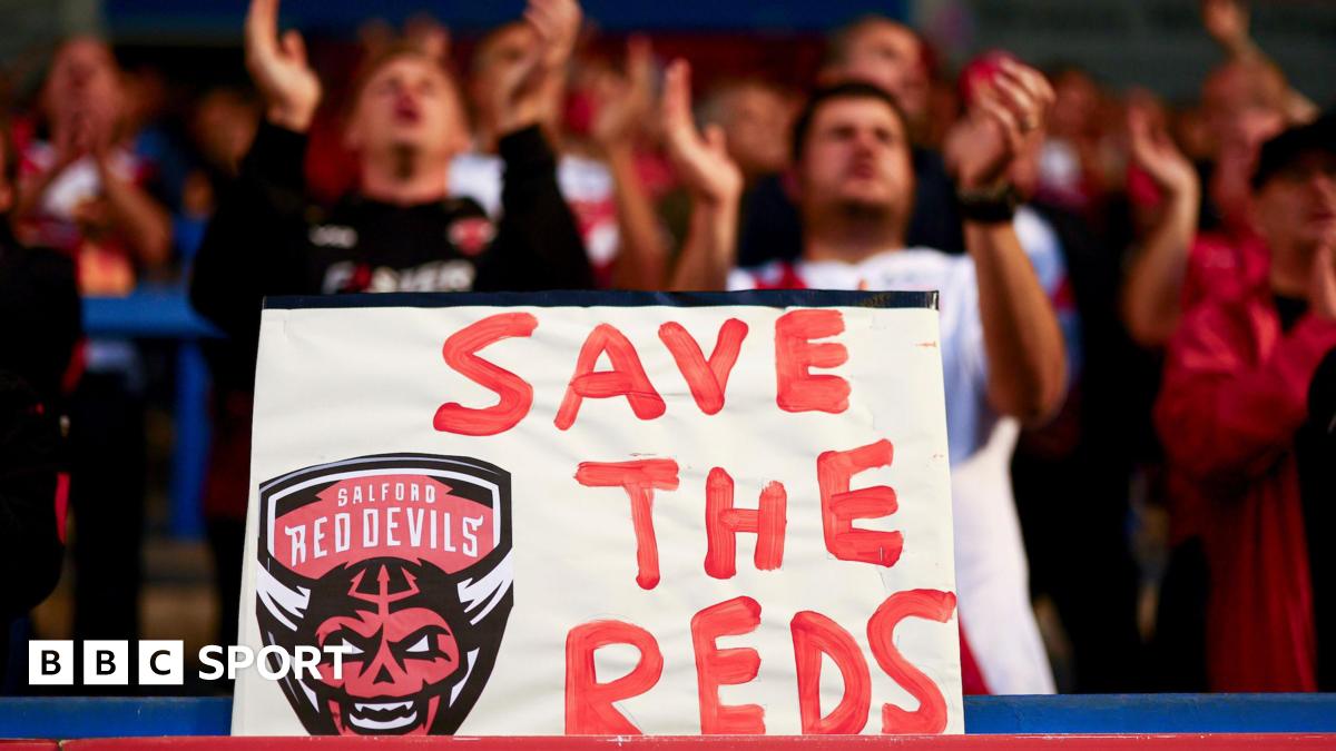 A 'Save the Reds' sign is held up by Salford Red Devils fans during last season