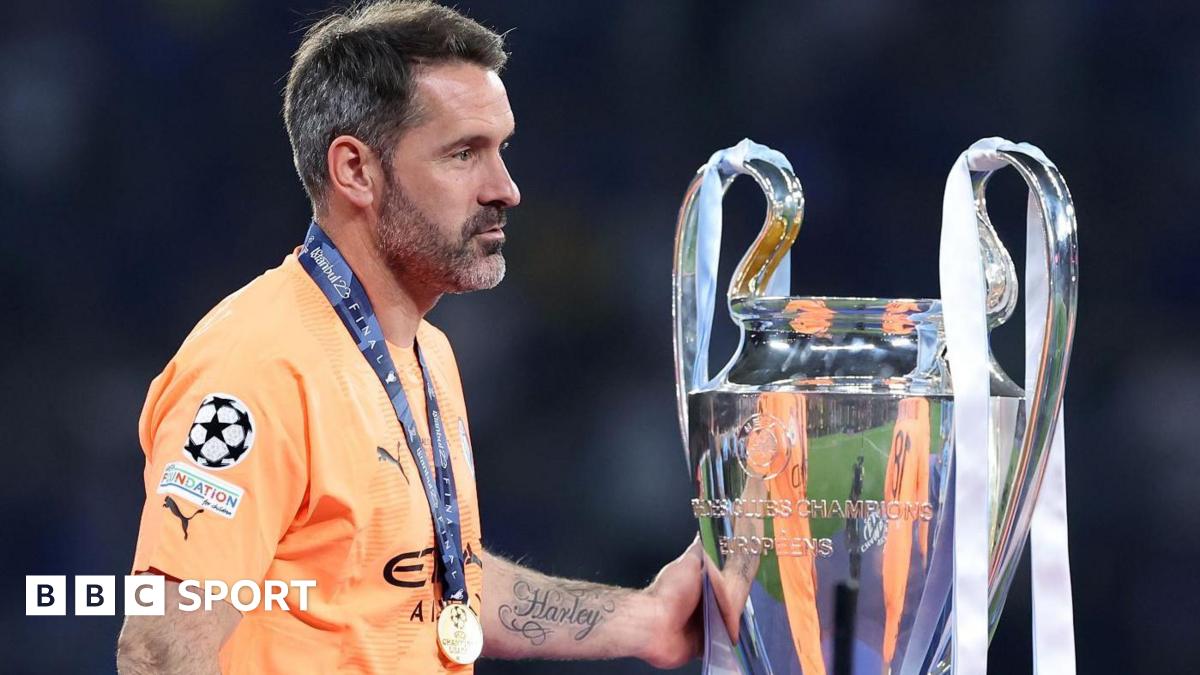 Scott Carson touches the Champions League trophy after Manchester City complete the Treble in 2022-23