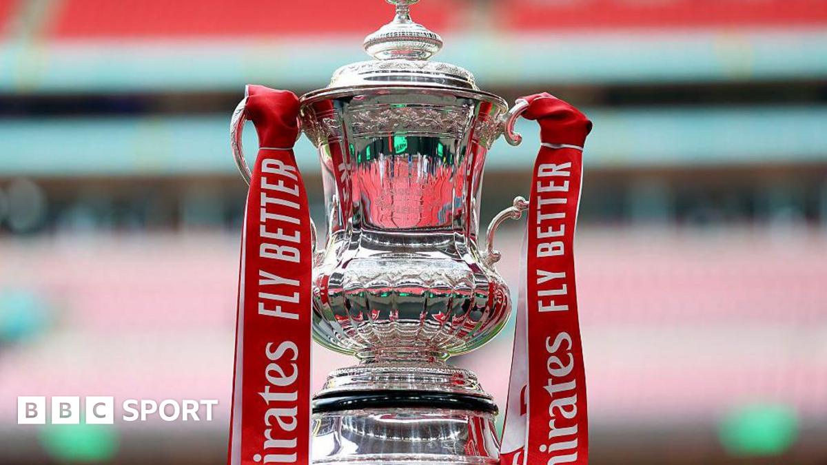 The FA Cup trophy, with red ribbons