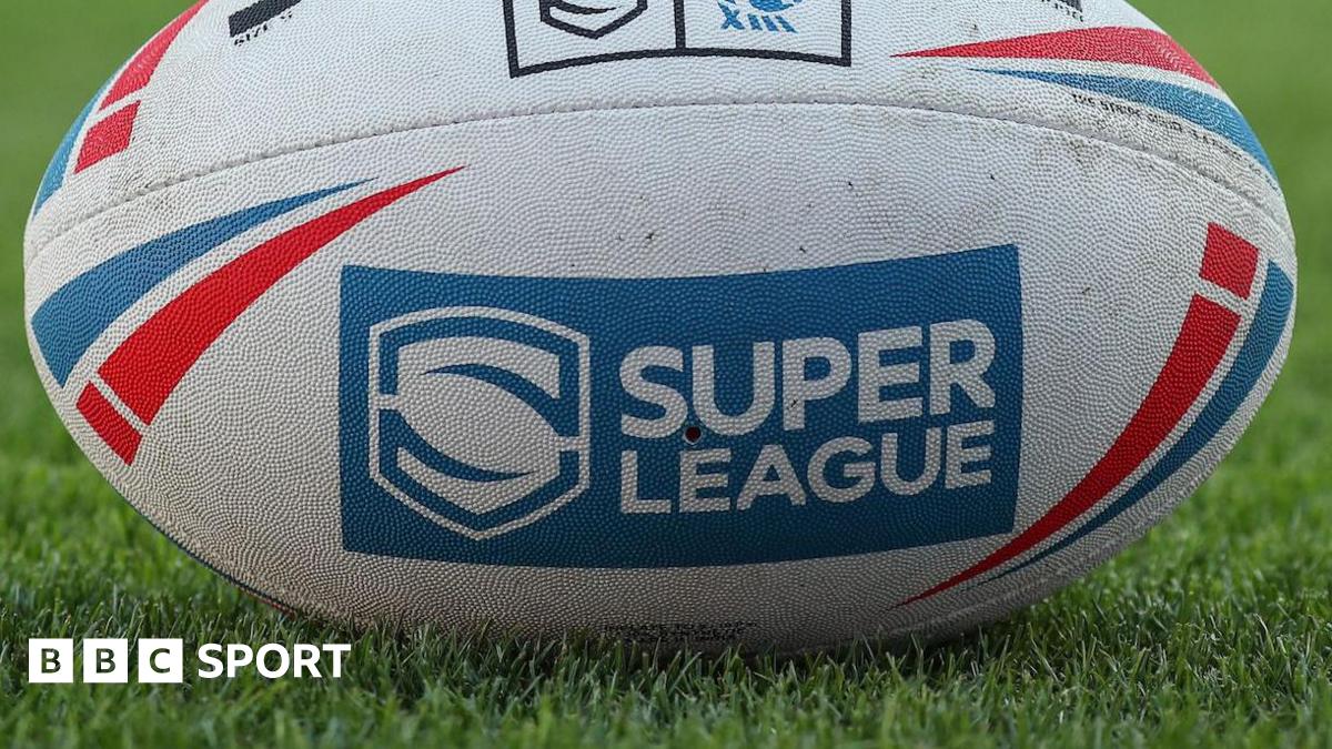 A rugby league ball, displaying the Super League logo, sits on the grass