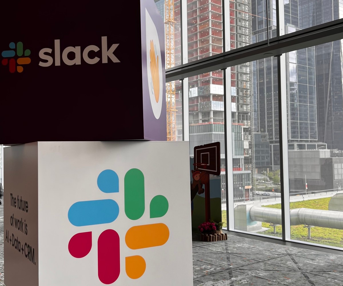 Cubes with Slack name and logo stacked on one another with city view in background.