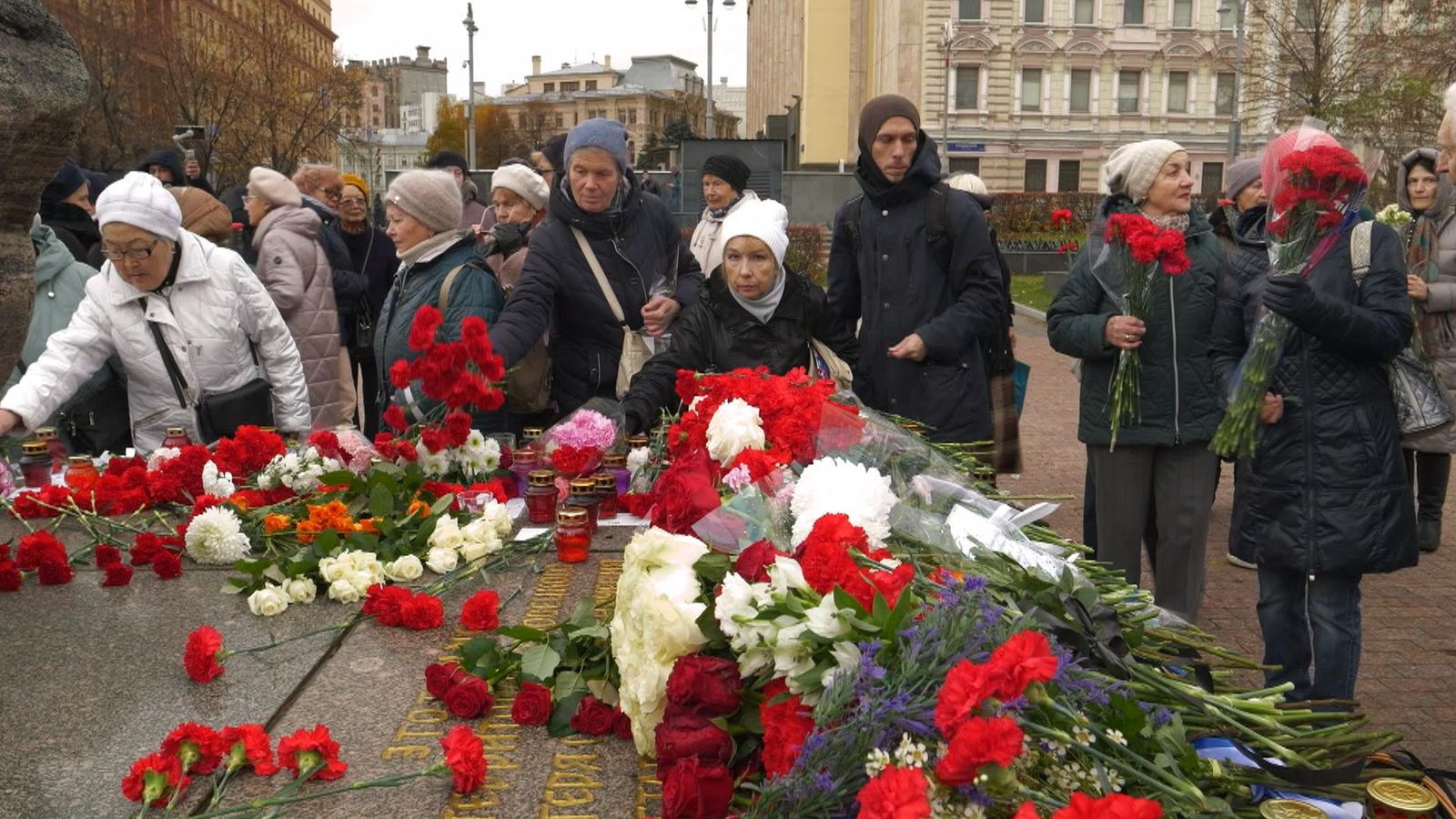 People lay flowers around a huge stone on Moscow's Lubyanka Square