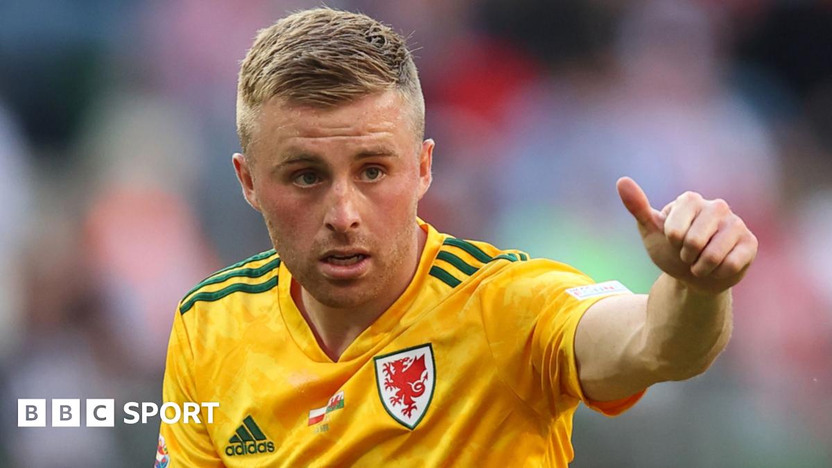 Joe Morrell puts a 'thumbs-up' while playing in a yellow Wales jersey