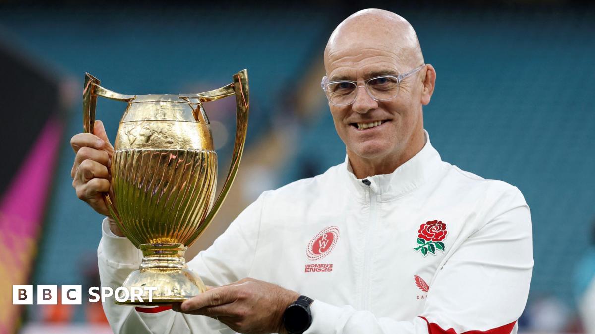 John Mitchell holding the World Cup trophy on the pitch at Twickenham following the England Red Roses win