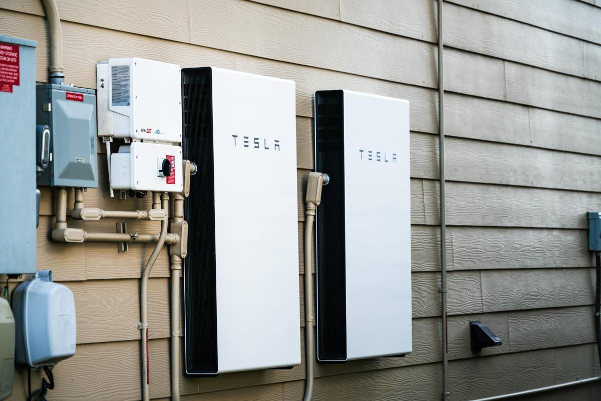 Two Tesla Powerwalls sit on the outside of a house.