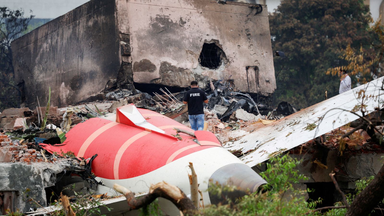 A fire officer stands next to the crashed aircraft. Pic: Reuters
