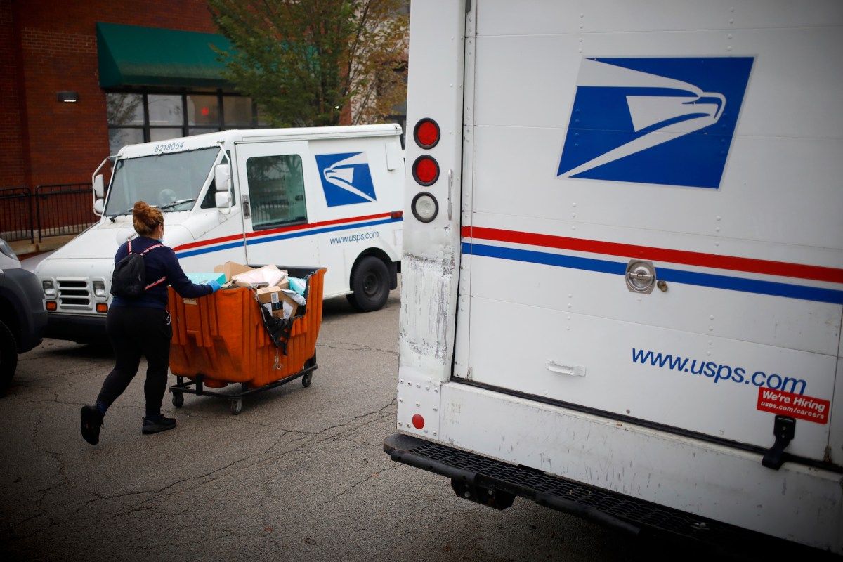 a postal worker worker pushes a mail cart outside a United States Postal Service (USPS) distribution center in Chicago.