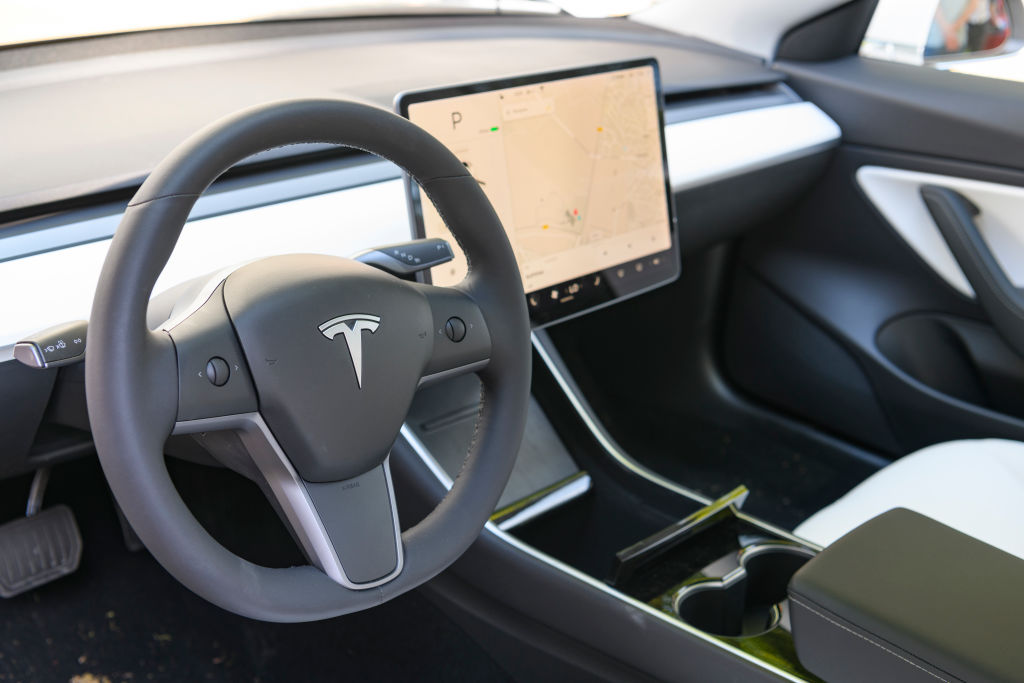 interior of Tesla EV showing steering wheel and center console